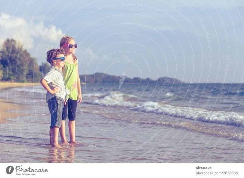 Happy children playing on the beach at the day time. Lifestyle Joy Relaxation Leisure and hobbies Playing Vacation & Travel Adventure Freedom Summer Sun Beach