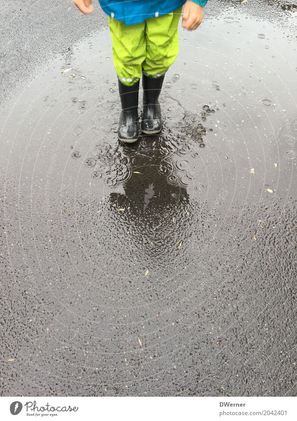 rainy weather Lifestyle Playing Adventure Dance Parenting Child Boy (child) 1 Human being Environment Nature Bad weather Rain Street Protective clothing Boots