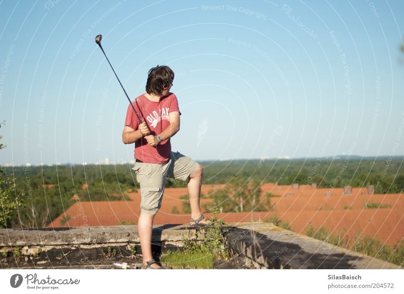 Golfing above the roofs Leisure and hobbies Summer Sports Golf course Human being Masculine Young man Youth (Young adults) 1 18 - 30 years Adults Roof Movement