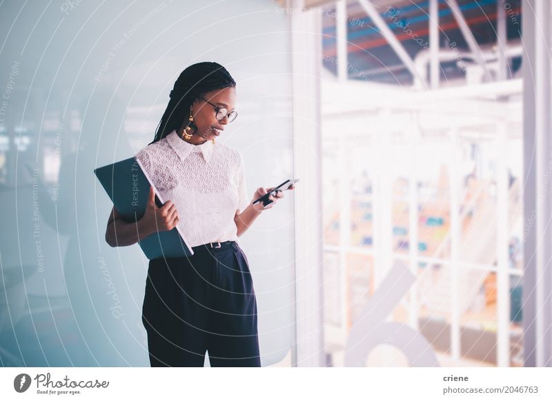 Young Afro American businesswoman using smartphone in office Lifestyle Reading Success Work and employment Office Financial Industry Business Career PDA