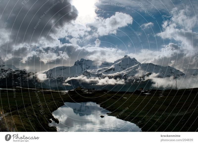 alpine ecstasy Nature Landscape Water Sky Clouds Storm clouds Sunrise Sunset Sunlight Winter Bad weather Alps Mountain Peak Snowcapped peak Lakeside Threat Blue