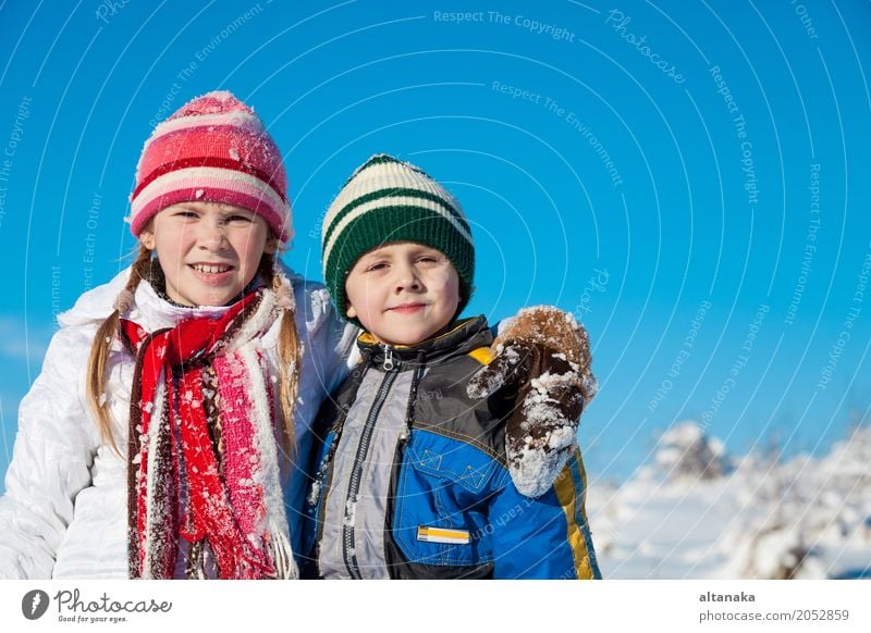 Cute little children playing in snow at a winter day. People having fun outdoors. Concept of Happy new year. Lifestyle Joy Beautiful Face Leisure and hobbies