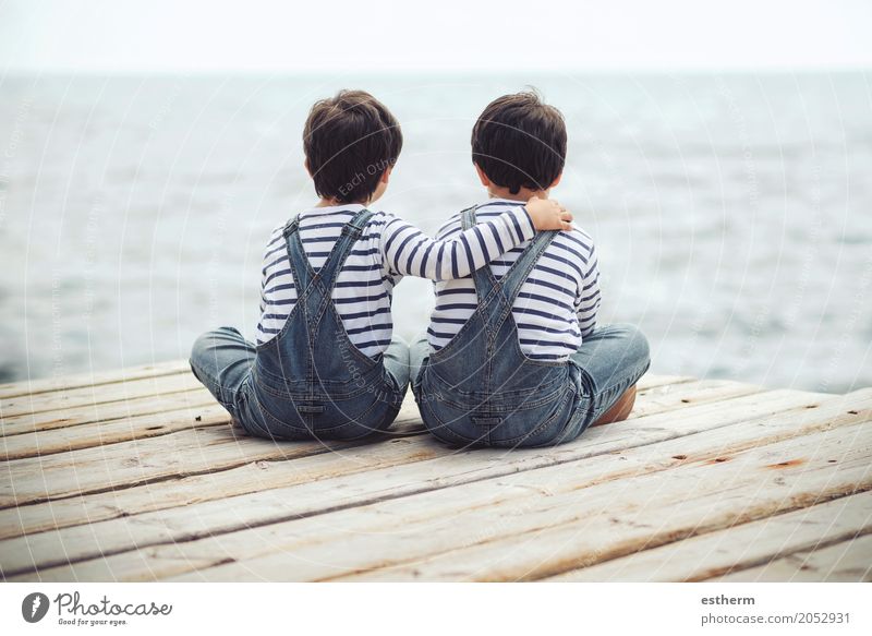 Brothers sitting at waterfront.Back view Lifestyle Human being Masculine Child Toddler Boy (child) Parents Adults Brothers and sisters Family & Relations