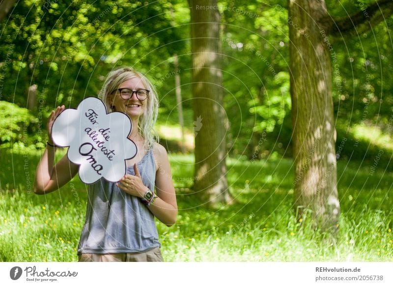 Woman with a sign in the park Grandmother Young woman Youth (Young adults) Feminine 18 - 30 years Adults Beautiful weather Summer Nature Meadow Eyeglasses