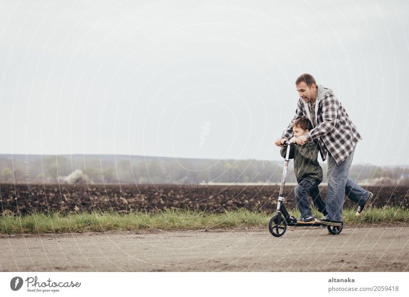 Father and son playing on the road at the day time. People having fun outdoors. Concept of friendly family. Lifestyle Joy Happy Leisure and hobbies Playing