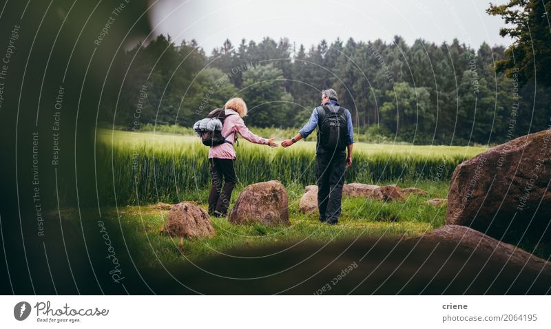 Mature Couple hiking trough green fields Lifestyle Joy Leisure and hobbies Hiking Sports Female senior Woman Male senior Man Partner Adults Senior citizen 2