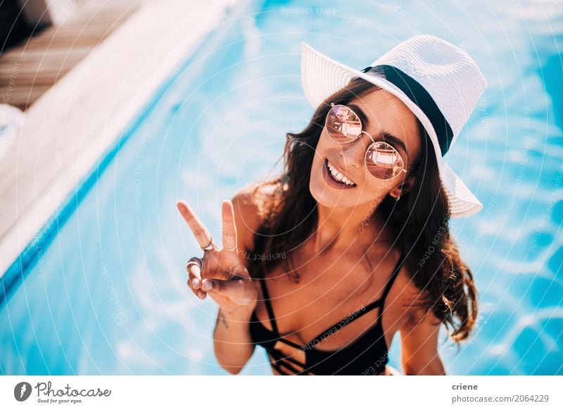 Woman making peace sign standing in swimming pool Lifestyle Joy Happy Relaxation Swimming pool Vacation & Travel Freedom Summer Human being Feminine Young woman