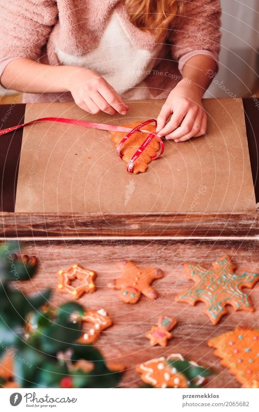 Girl tying baked Christmas gingerbread cookies with ribbon Lifestyle Decoration Table Feasts & Celebrations Christmas & Advent Craft (trade) Human being Hand 1