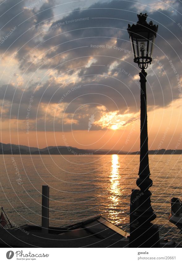 sunset lantern Colour photo Exterior shot Deserted Twilight Silhouette Sunlight Back-light Waves Water Clouds Sunrise Sunset Lakeside Lake Lucerne Kitsch