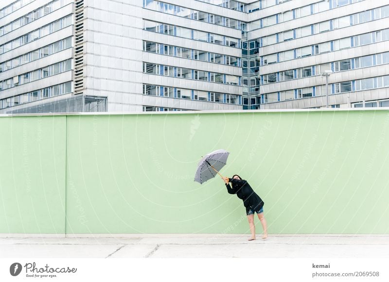 Woman with umbrella in front of a green wall, in the background skyscrapers Joy Leisure and hobbies Vacation & Travel Trip Adventure Freedom City trip