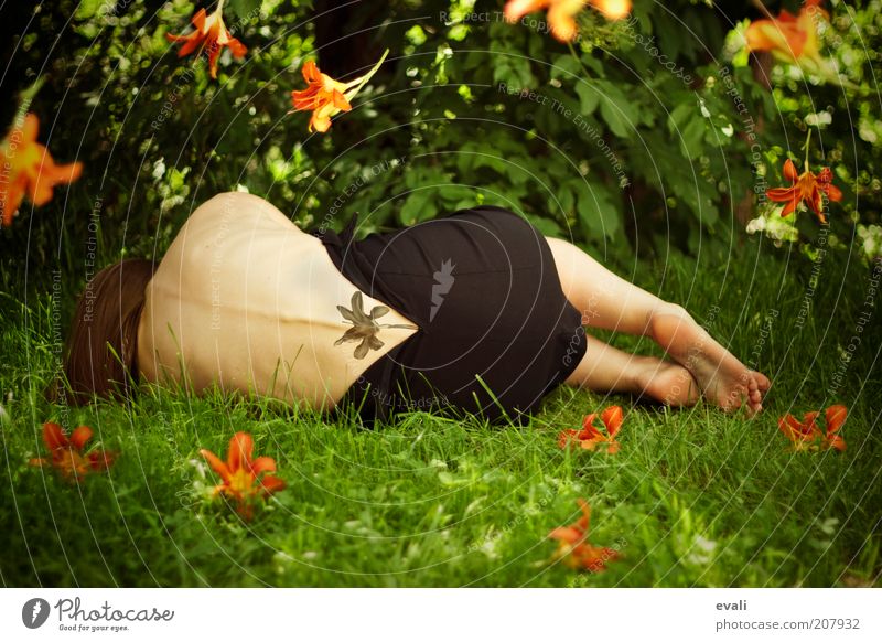 Bloom again Human being Feminine Woman Adults Body Back Feet 1 Summer Flower Grass Garden Park Lie Green Authentic Orange Tattoo Colour photo Exterior shot Day