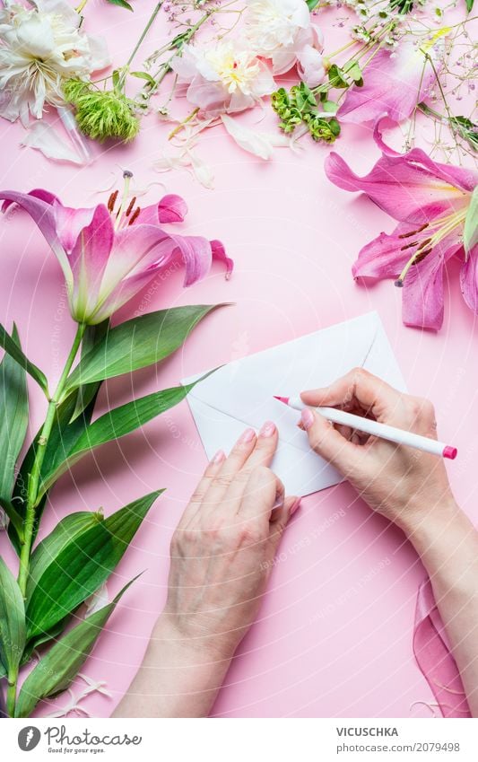 Female hands write greeting card on pink table with flowers Lifestyle Style Design Living or residing Decoration Table Feasts & Celebrations Valentine's Day