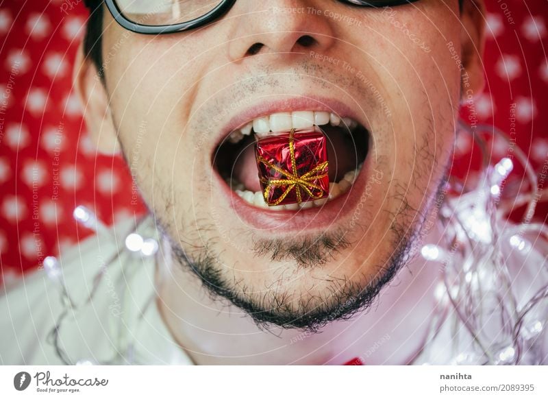 Close up of a young man biting a gift box Lifestyle Joy Feasts & Celebrations Christmas & Advent New Year's Eve Human being Masculine Young man