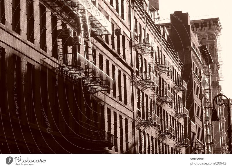 South of Houston (SoHo) Soho New York City Fire ladder North America USA cast iron turn of the century old houses Sun Sepia