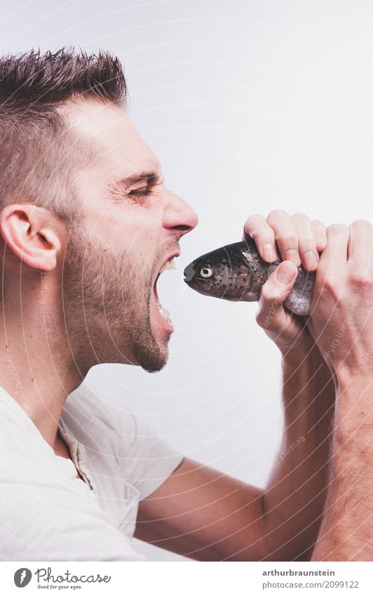 Young man eats fresh fish Food Fish Trout Brown trout Nutrition Eating Organic produce Slow food Shopping Healthy Eating Leisure and hobbies Fishing (Angle)