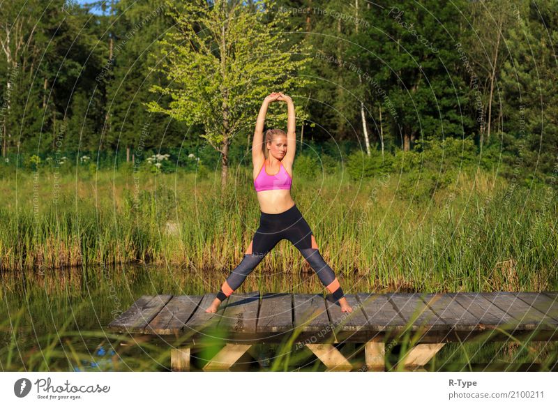 A sporty woman doing yoga and stretching exercises Lifestyle Wellness Sports Yoga Human being Woman Adults Nature Park Fashion Blonde Fitness aerobics active