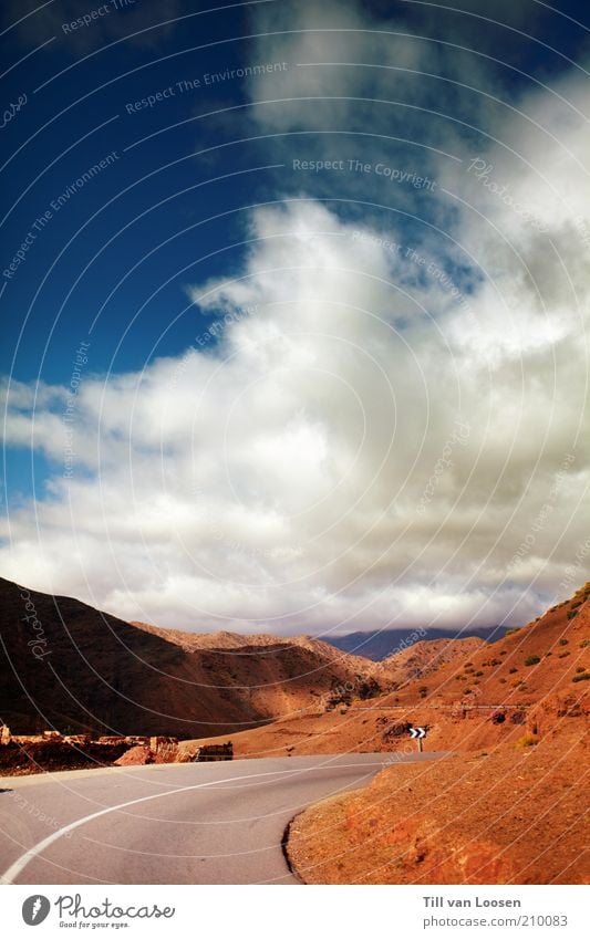 Road through Red Environment Nature Sky Clouds Summer Weather Rock Traffic infrastructure Street Blue Gray White Signs and labeling Morocco Mountain Atlas