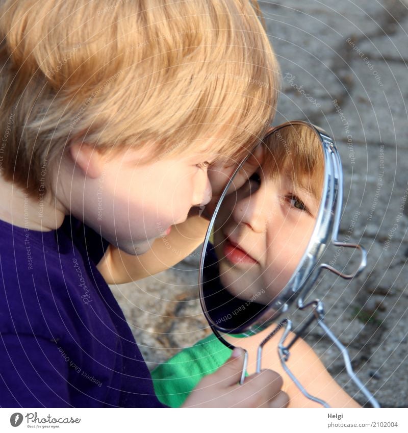 little boy looks into a mirror and sees his face Human being Masculine Toddler Boy (child) Infancy 1 1 - 3 years Clothing T-shirt Blonde Mirror Paving stone