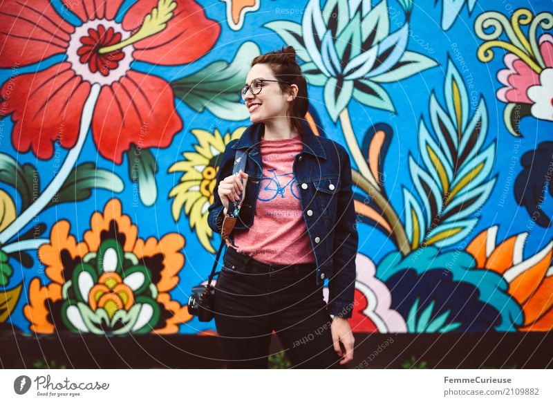 Young attractive woman with glasses, jeans jacket and reflex camera in front of colorful wall Feminine Young woman Youth (Young adults) Woman Adults 1