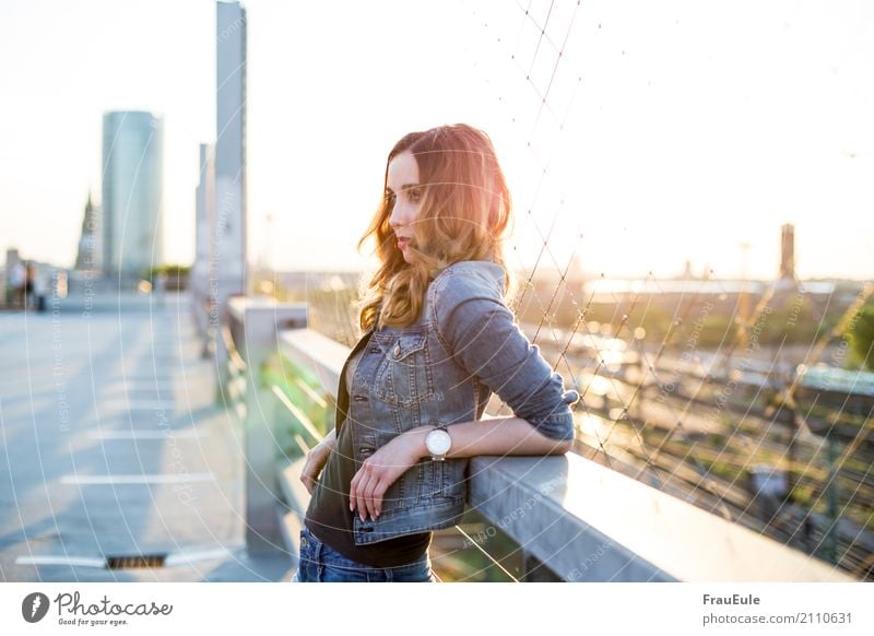 above the roofs II Feminine Young woman Youth (Young adults) Woman Adults 1 Human being 18 - 30 years Town Skyline Parking garage Roof Jeans Jeans jacket Clock