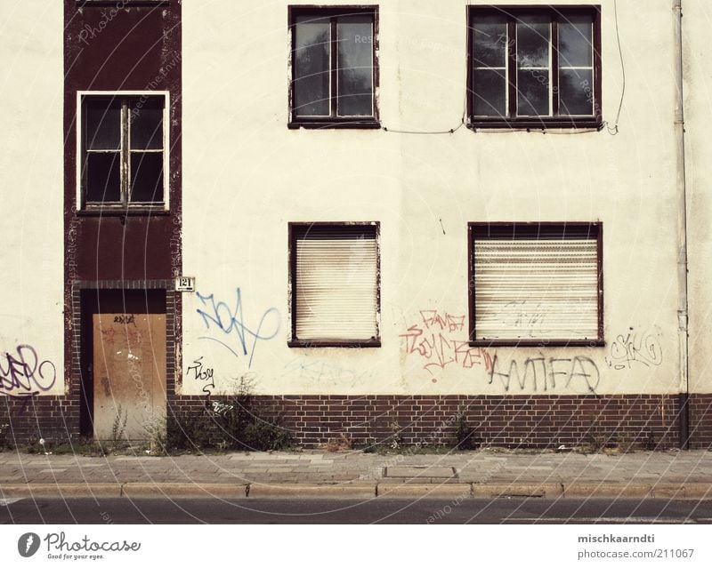 Status: Empty Deserted House (Residential Structure) Ruin Building Facade Window Door Old Hideous Roller shutter Street Sidewalk Weed Graffiti