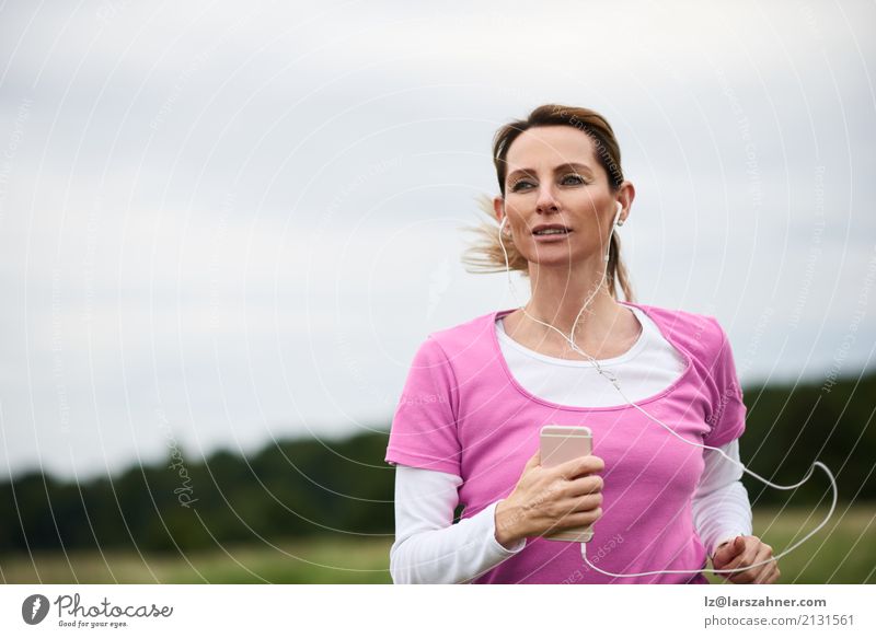 Concentrated woman running through field Lifestyle Face Summer Music Sports Jogging PDA Woman Adults 1 Human being 30 - 45 years Nature Autumn Blonde Fitness