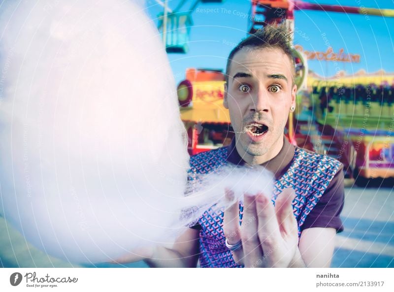 Young man eating a cotton candy in a fair Food Candy Cotton candy Eating Lifestyle Joy Feasts & Celebrations Fairs & Carnivals Human being Masculine