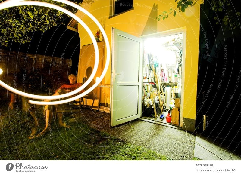 At night in the garden Garden 1 Human being 45 - 60 years Adults Barn Spiral Flashlight Gardenhouse Light Night Illuminate Arrangement Door Open Sit