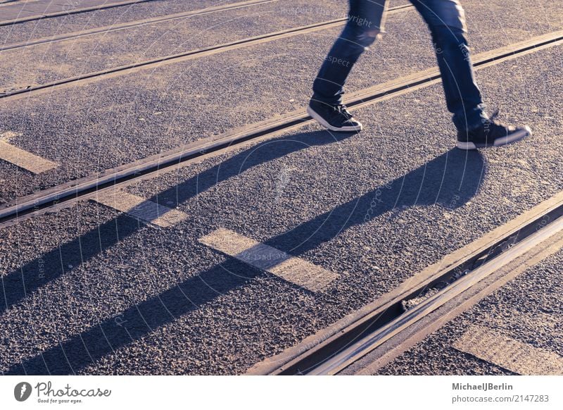 Long shadows of pedestrians between tram tracks Human being 1 Town Public transit Road traffic Street Going Walking Berlin Germany City Sunset Shadow Feet