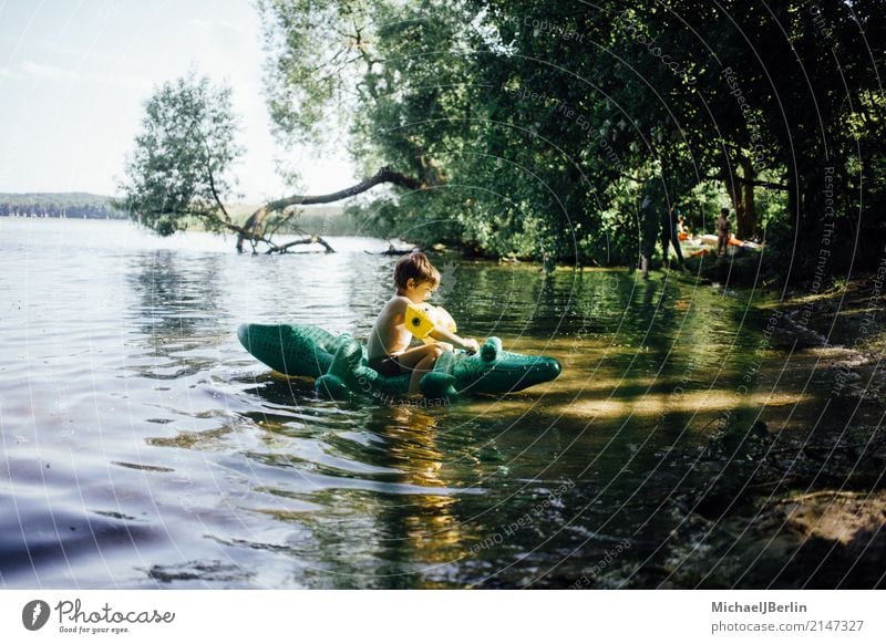 Boy sitting on air-filled plastic crocodile in a lake Joy Swimming & Bathing Masculine Toddler Boy (child) 1 Human being 3 - 8 years Child Infancy Water Summer