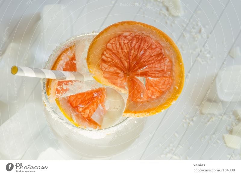 Delicious soft drink with grapefruit, coconut flakes, ice cubes and drinking straw Beverage Cold drink Grapefruit Coconut shred coconut Ice cube Organic produce