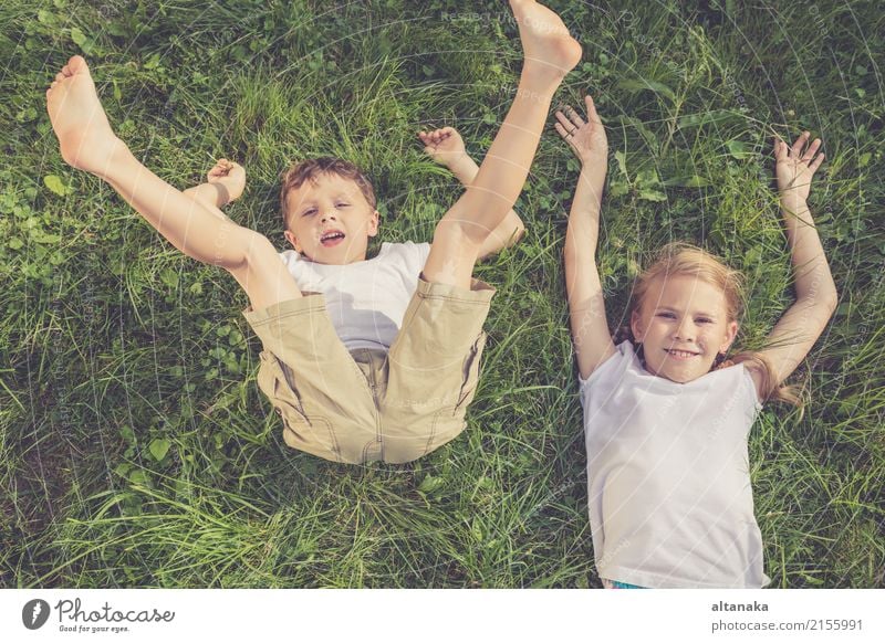 Two happy children playing on the grass at the day time. Concept Brother And Sister Together Forever Lifestyle Joy Happy Beautiful Face Leisure and hobbies