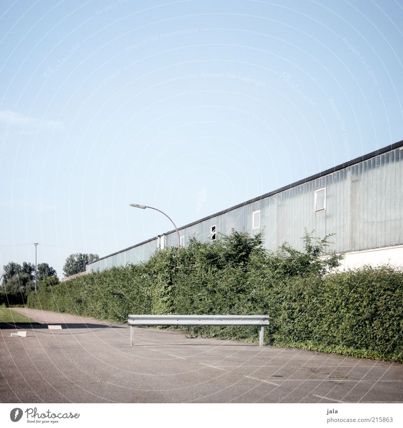 on a hall. Sky Plant Bushes Industrial plant Places Manmade structures Building Architecture Hall Street lighting Parking lot Blue Gray Green Colour photo