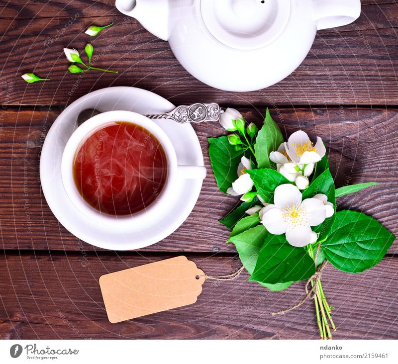 hot black tea in a white cup Breakfast Beverage Tea Spoon Table Flower Leaf Wood Fresh Hot Above Retro Brown Green Black White Tradition Jasmine drink food Top