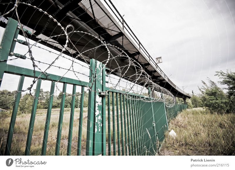 locked and excluded Looking Moody Fear Railroad tracks Fence Barbed wire Gate Barrier Bridge Commuter trains Grass Closed Dangerous Bans Protest New building