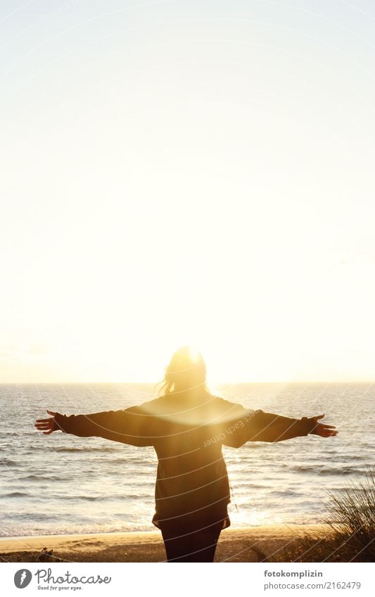 Woman with outstretched arms in front of shining sunset at the sea Far-off places Freedom Ocean Balance Spirituality Solar Power mental Sunrise Mystic Hope