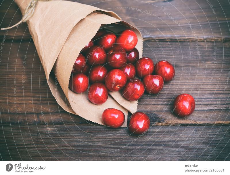 red cherry in a paper bag Fruit Dessert Eating Vegetarian diet Juice Summer Garden Table Paper Wood Fresh Natural Retro Juicy Brown Red background Berries