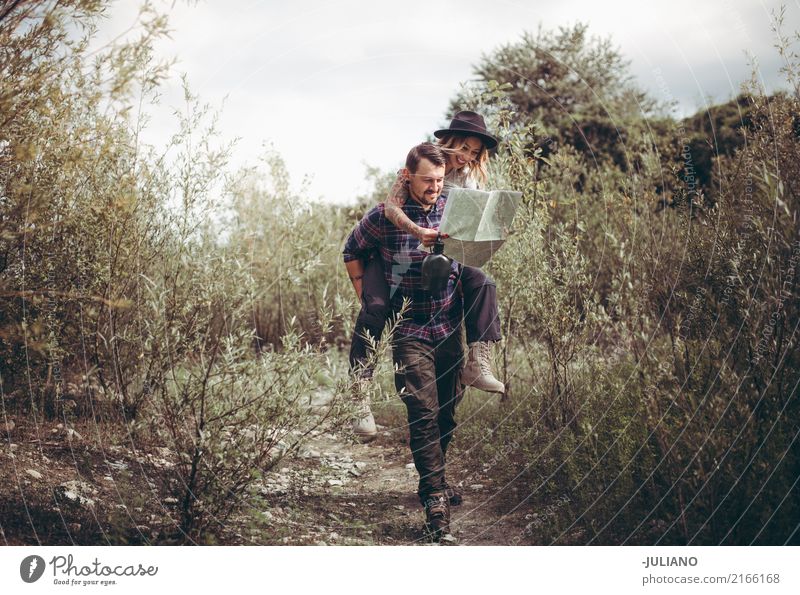 sweet couple making piggyback while looking at map Lifestyle Vacation & Travel Tourism Trip Adventure Far-off places Freedom Expedition Camping Summer vacation