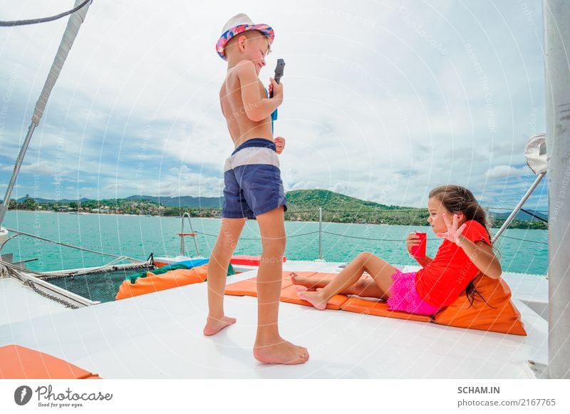 Cute kids on a boat trip. Boy is playing a toy guitar for his beautiful girlfriend Lifestyle Joy Freedom Summer Island Infancy Youth culture Sail Smiling