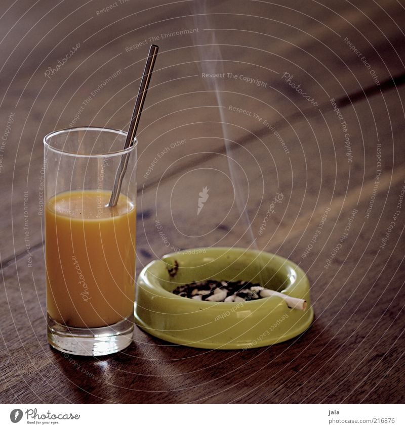 balanced diet Food Beverage Juice Glass Straw Ashtray Ashes Cigarette Wood Unhealthy Orange juice Vitamin Nicotine Colour photo Interior shot Deserted