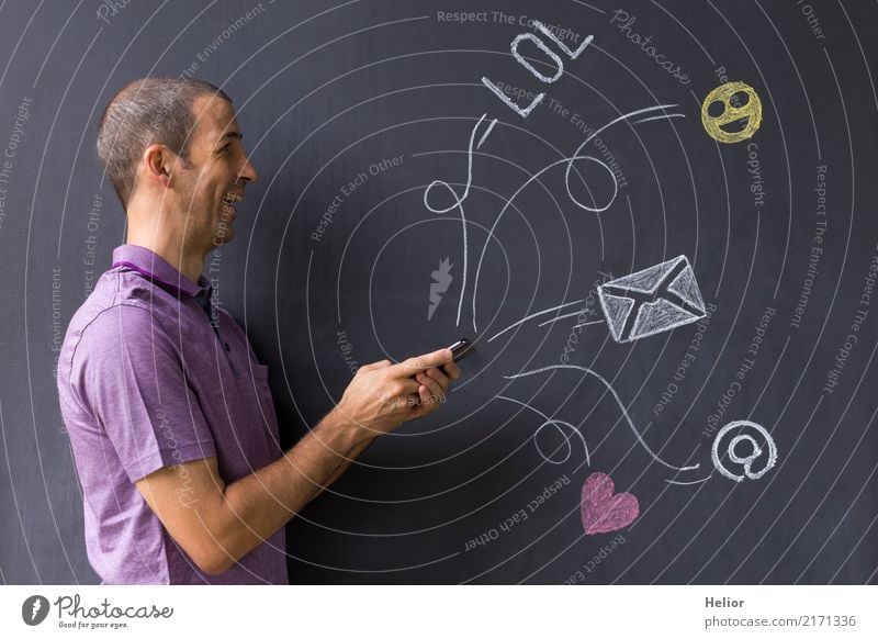 Man with mobile phone in front of chalk-drawn social media symbols on a blackboard (Topic: Social Media Overload) Lifestyle Joy Cellphone PDA Internet Masculine