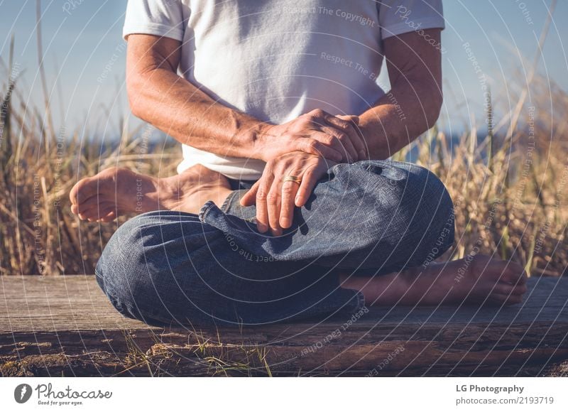 Man sitting in a relaxed yoga pose at the beach. Relaxation Meditation Sun Yoga Adults Old Sit Natural Power Serene 50-60 years Action color image