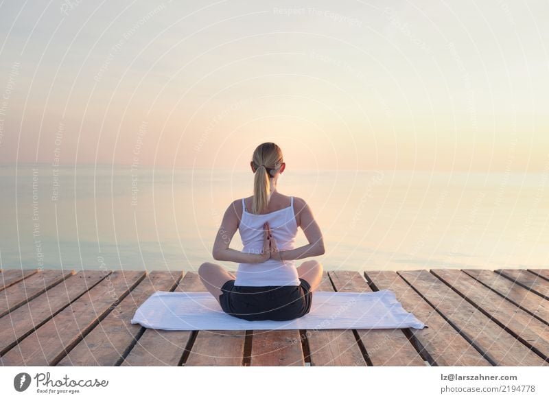 Young woman practising yoga by sea Wellness Relaxation Meditation Vacation & Travel Summer Ocean Yoga Woman Adults Blonde Breathe Power Serene Energy conscious