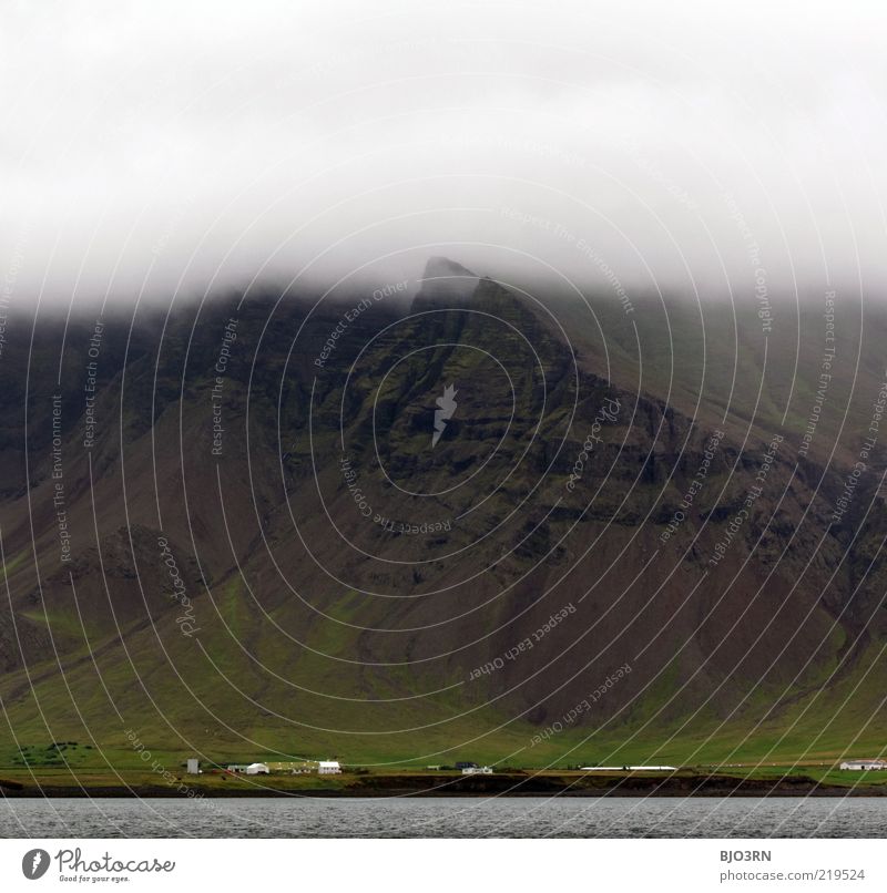 Berg's got a headache. Iceland. Fog Mountain Rock Stone Grass Gray Black Green House (Residential Structure) Inhabited Populated Coast Water Dreary Diffuse Low