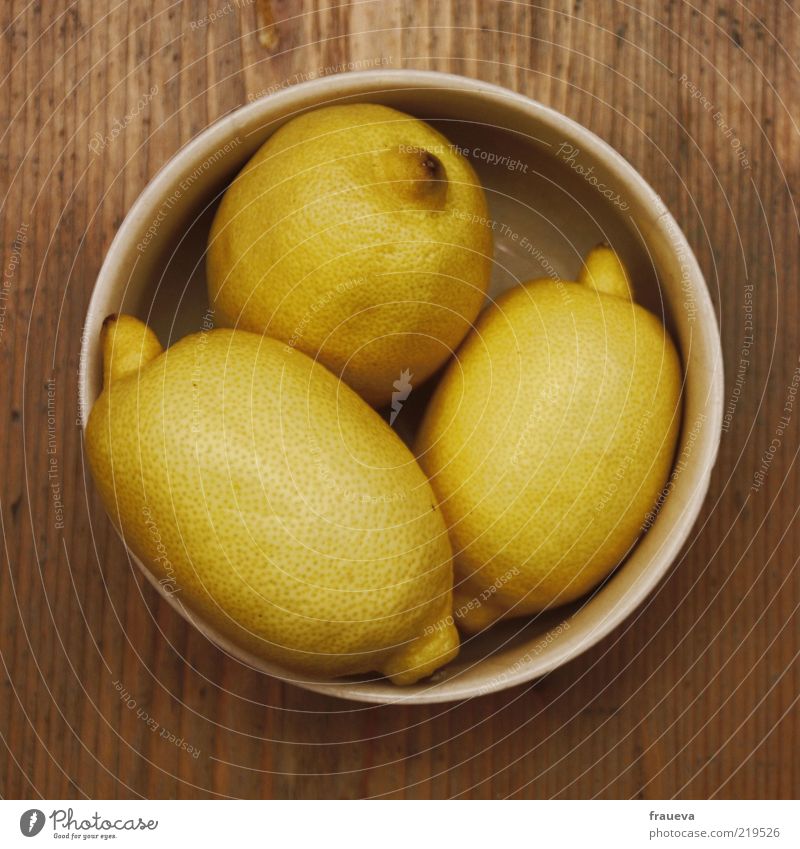 Trick or treat! Food Fruit Nutrition Bowl Sour Wooden table Colour photo Interior shot Close-up Deserted Artificial light Bird's-eye view Lemon Lemon yellow 3