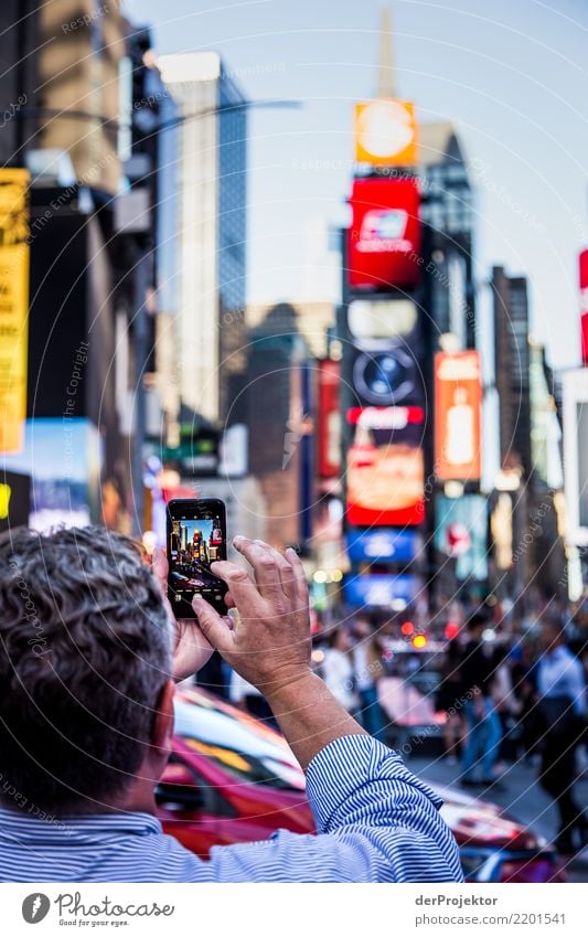 New York Times Square with Smartphone in the foreground in New York Central perspective Deep depth of field Sunlight Reflection Contrast Shadow Light Day