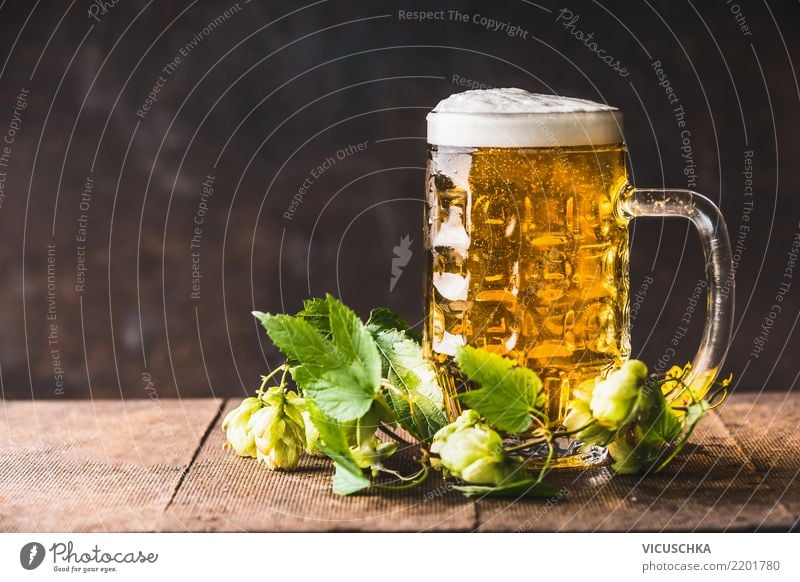 Beer mug with foam on the table with fresh hops Beverage Cold drink Style Design Party Restaurant Bar Cocktail bar Yellow Background picture Pub Cup