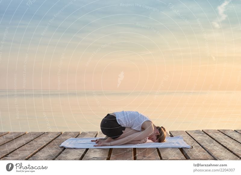 Young woman practicing yoga by sea Wellness Relaxation Meditation Vacation & Travel Summer Ocean Yoga Woman Adults Blonde Breathe Power Serene Energy conscious