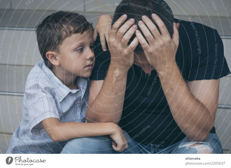 Portrait of young sad little boy and father sitting outdoors at the day time. Concept of sorrow. Face Child Boy (child) Man Adults Parents Father