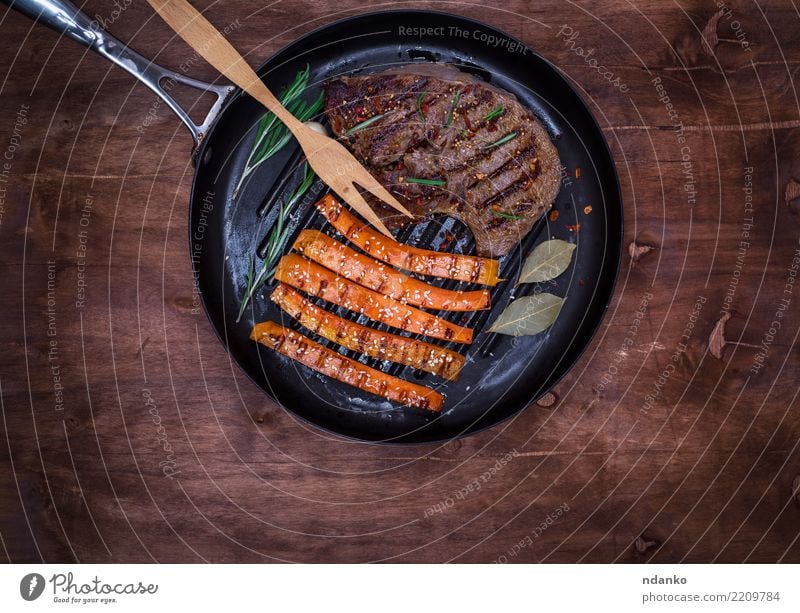 frying pan with a piece of fried beef Meat Vegetable Herbs and spices Nutrition Lunch Pan Fork Table Restaurant Wood Hot Delicious Above Brown Black Meal